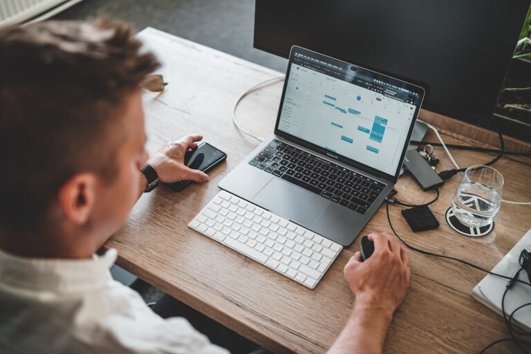 Business professional researching search visibility and authority signals using a laptop and smartphone