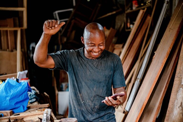 Small business owner using a smartphone, representing customer reviews and local AI search recommendations